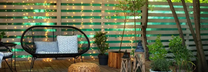 Gemütliche Sitzecke auf Holzterrasse mit Beleuchtung